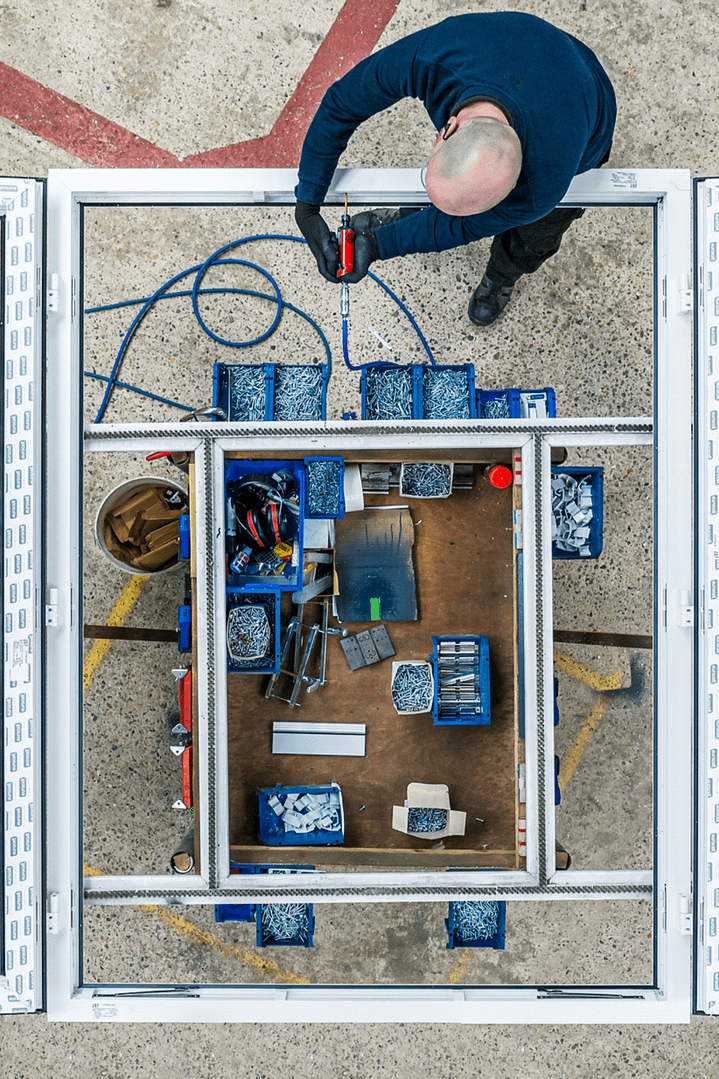 overhead picture of man working on window in factory