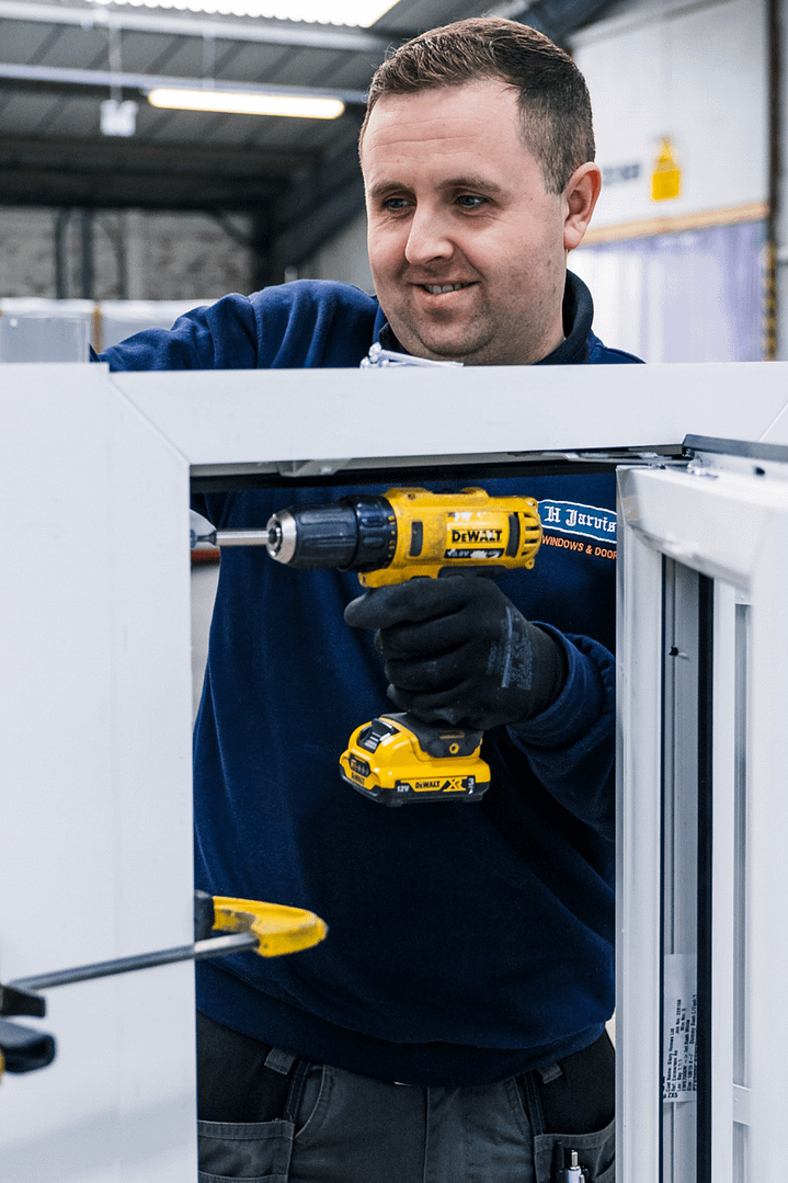 man using drill on window
