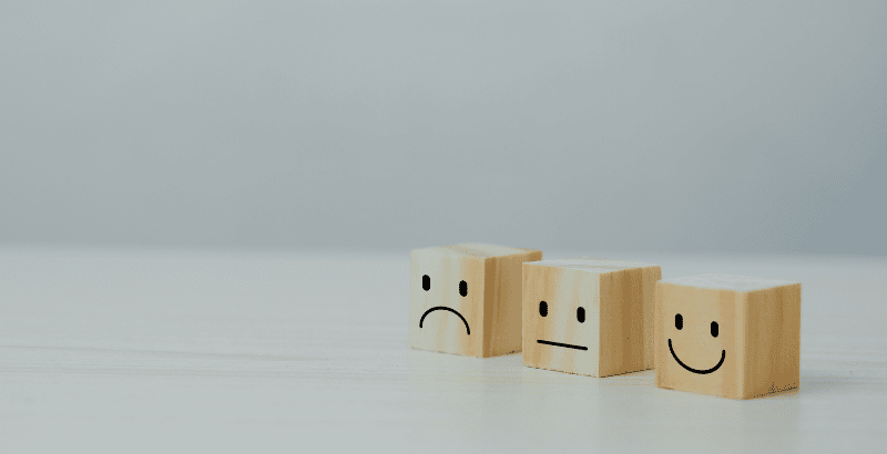 three wooden cubes with faces drawn on them