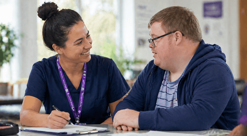 Healthcare professional supporting a man with learning disabilities